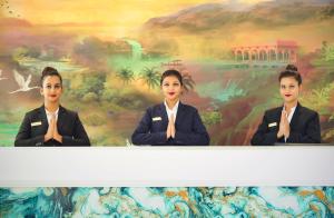 a painting of three women in uniform in front of a mural at Seven Eleven Hotels and Club in Bhayandar