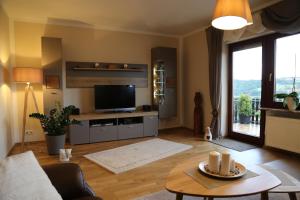 a living room with a television and a table at Feriendomizil Renate in Bad Sobernheim