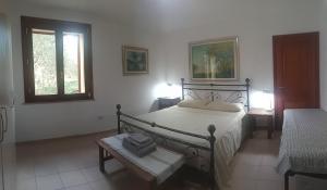 - une chambre avec un lit, une table et deux fenêtres dans l'établissement Residence degli ulivi, à Ossi