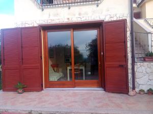 una porta aperta di una casa con patio di Residence degli ulivi a Ossi