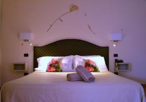 a bedroom with a white bed with flowers on it at Hotel Saccardi & Spa - Adults Only in Caselle di Sommacampagna
