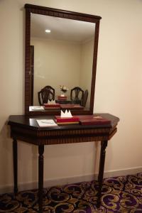 a mirror on top of a table with books on it at Amjad Al Deafah Hotel in Makkah