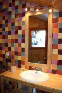 ein Bad mit einem Waschbecken und einem Spiegel in der Unterkunft LATITUDE 47 in Châtel