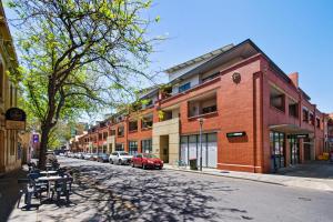 una calle con edificios y coches estacionados en la calle en Swainson on Union en Adelaida