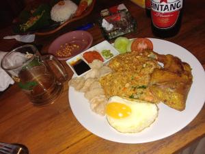 a plate of food with an egg on a table at Pondok Diana in Jasri