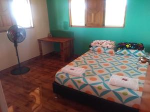 Schlafzimmer mit einem Bett und einem Ventilator in der Unterkunft Finca campestre y recreativa los potrillos in Doradal