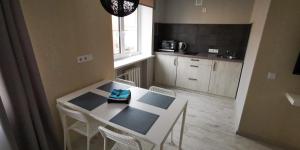 a small kitchen with a white table and chairs at Central Moon Miluva in Daugavpils