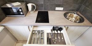 a kitchen counter with a drawer with utensils on it at Central Moon in Daugavpils