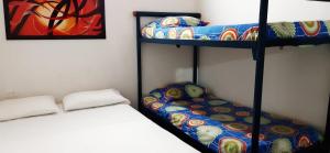 two bunk beds in a room with a bed at Hotel Acapulco in Girardot