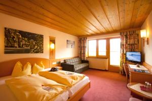 a hotel room with a bed and a television at Hotel Garni Fernblick in Fiss