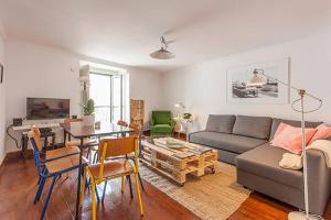 een woonkamer met een bank en een tafel bij Oak Valley Flats Bairro Alto in Lissabon