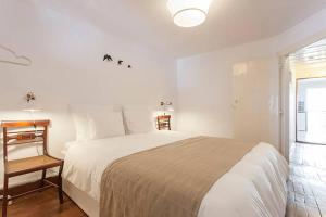 een witte slaapkamer met een groot bed en een raam bij Oak Valley Flats Bairro Alto in Lissabon