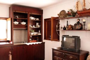 un soggiorno con TV e alcuni scaffali di Quinta da Imaculada a Arcos de Valdevez