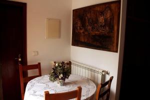 un tavolo da pranzo con un vaso di fiori sopra di Quinta da Imaculada a Arcos de Valdevez Altre 11 foto