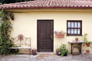 una casa con una porta, una panchina e un tavolo di Quinta da Imaculada a Arcos de Valdevez