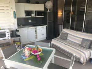 - une cuisine et une table avec un bol de fleurs dans l'établissement Appartement vue mer Anse des rochers, à Saint-François