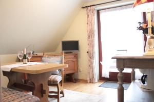 ein Wohnzimmer mit einem Tisch und einem TV in der Unterkunft Gästezimmer Neumair in Undeloh