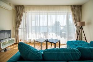 sala de estar con sofá azul y ventana grande en White Cliffs, Byala, en Byala