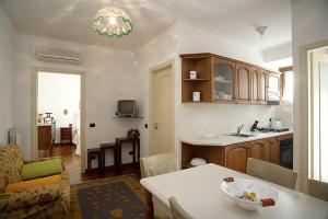 a living room with a table and a kitchen at Residence Criro in Marina Palmense