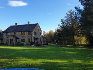 a large stone house with a large yard at Pine Ridge Retreat With FREE GOLF and Air Conditioning in Morpeth