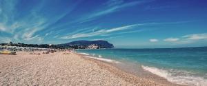 a beach with people laying on the sand and the ocean at Belo Horizonte in Civitanova Marche