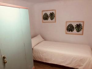a bedroom with a bed and two framed prints of plants at le petit caprice in Haro