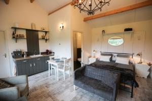 a bedroom with a large bed and a kitchen at De Rolders in Wapenveld