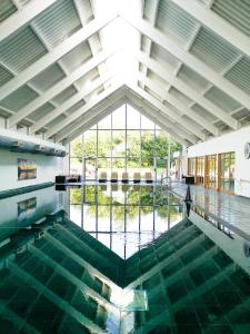 a pool of water in a building with a large window at Mill Green Cottage, On site Pools & Spa access in Somerford Keynes