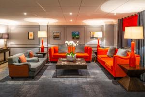Copthorne Hotel Plymouth في بلايموث: غرفة معيشة مع أثاث برتقالي وطاولة