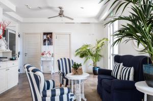 a living room with blue and white chairs and a table at Hotel Nautilus in Cagliari