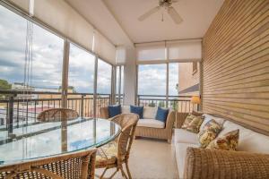 een woonkamer met een glazen tafel en stoelen bij Apartamento con vistas al mar in Santiago de la Ribera