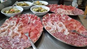 una mesa cubierta con bandejas de carne y otros alimentos en Agriturismo al Marter, en Ledro