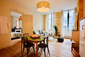 un soggiorno con tavolo e una camera da letto di Maison Bouquiere La Cabrerie a Bordeaux