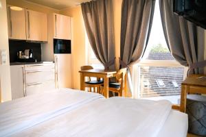 1 dormitorio con 1 cama y cocina con ventana en Boardinghouse City Home, en Bielefeld