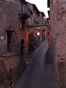 オルヴィエートにあるAppartamento Porta Maggioreのアーチ道のある古い建物内の路地