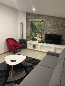 a living room with a couch and a tv at Casa do Ribeiro Frio in Santana