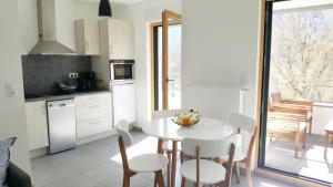 a kitchen and dining room with a white table and chairs at Les Picaillons - A 200m du lac in Aix-les-Bains +9 photos