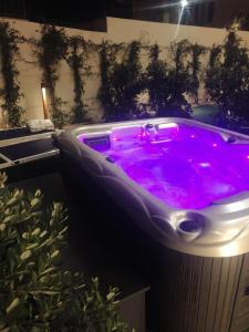 a hot tub with purple water in a bathroom at Hotel Nautilus in Cagliari