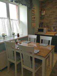 a kitchen with a wooden table with four chairs at Sweet-S in Boryspilʼ