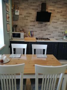 a kitchen with a wooden table and four chairs at Sweet-S in Boryspilʼ