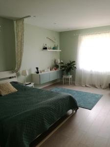 a bedroom with a green bed and a window at Sweet-S in Boryspilʼ
