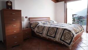 a bedroom with a bed and a dresser and a window at Pompei Campania Felix in Poggiomarino