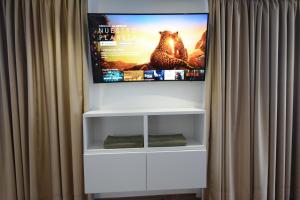a flat screen tv hanging on a wall behind a curtain at Loft del Mar 2 Jandia in Playa Jandia
