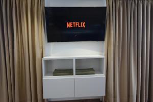 a white shelf with a netflix sign behind a curtain at Loft del Mar 2 Jandia in Playa Jandia