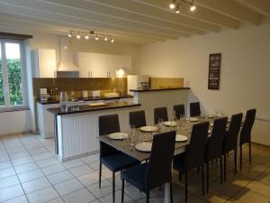 une salle à manger avec une table et des chaises ainsi qu'une cuisine dans l'établissement Le Cottage de Paul et Angéline, à Boismé