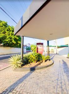 una gasolinera con un edificio y algunas plantas en Maktub Hotel en Floriano