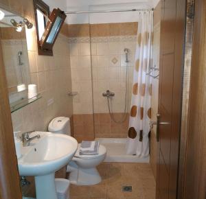 a bathroom with a sink and a toilet and a shower at Stella Meri Studios - Apartments in Nea Skioni