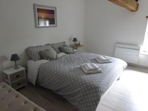 ein weißes Schlafzimmer mit einem Bett und einem Stuhl in der Unterkunft Le Cottage de Paul et Angéline in Boismé