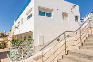 Una casa blanca con escaleras al frente. en Casa Ricardo BEACH Apartment, en Morro del Jable
