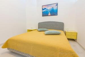 1 dormitorio con 1 cama amarilla y 2 almohadas en Casa Ricardo BEACH Apartment, en Morro del Jable